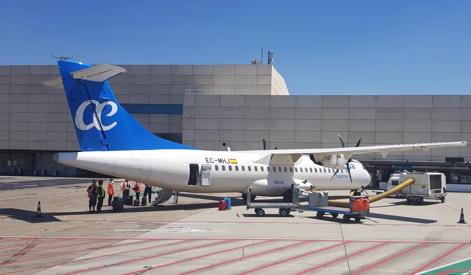 Un avión de Air Europa estacionado en una plataforma de aeropuerto junto a vehículos de asistencia