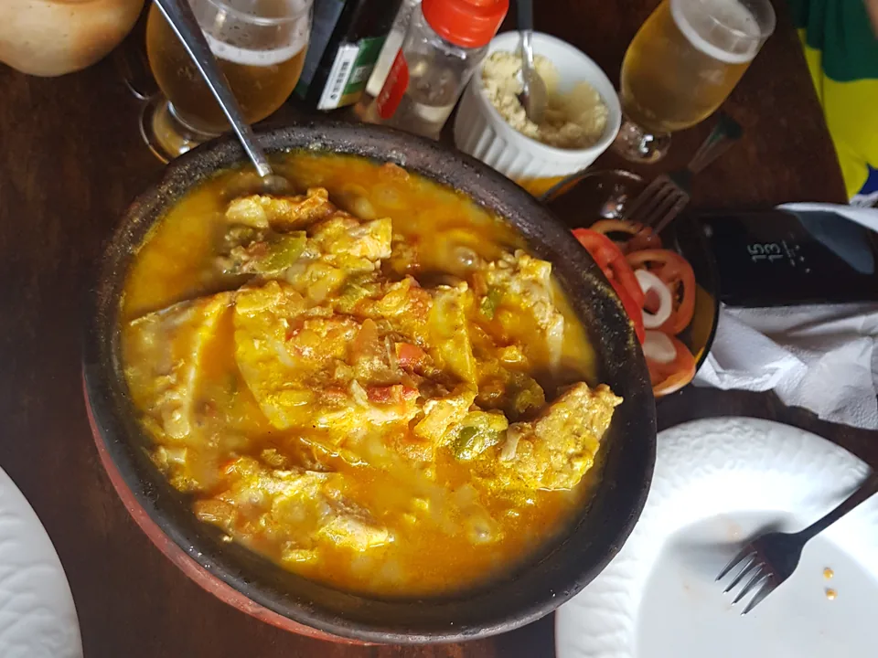 Una cazuela de guiso dorado servida en una mesa de restaurante